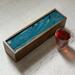 Soft shades of blue and green with ribbons of gold and white on this tea box.