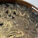 Close up of the design on this large wooden serving tray.  Gold and bronze metallic paint swirl together on the black background.  Finished in durable glossy resin.