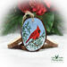 A hand-painted northern cardinal wood slice Christmas ornament available for purchase exclusively at Cove Creek Photography.