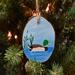 A hand-painted mallard wood slice ornament on a Christmas tree.  The ornament is available at Cove Creek Photography.