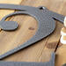 Close up of silver vein powder coat on our oval metal house number sign.