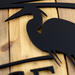 Close up of matte black powder coat on our custom metal address plaque with a great blue heron and cattails lake scene.