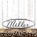 Oval family last name metal sign with script font, in silver vein powder coat.