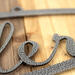 Close up of silver vein powder coat on our metal oval family sign with script font.