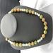 Agate stone with multiple colors. Gold spacers are used between each bead. The necklace is 20 inches long. Included are matching earrings.