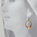 Model wearing fun, bright citrus fruit earrings, with lemon as the focal point and seed beads in yellow, orange, pink and green. 