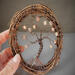 front view of wreath being help in the artosts hand to show size proportion detail