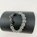 Agate stones of gray and black mixed with chain maille and a rhinestone-encrusted black toggle clasp. 