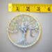 A measuring tape shows the small size of 3 inches. The tree is small but makes a bif appearance in any room