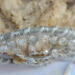 the top view shows yarn and beads anchored to metal hoop