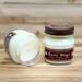 Banana bread scented soy candle in 8oz mason jar. One jar standing up with lid on and one jar on its side with lid off.