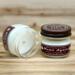 Fir tree scented soy candle in 4oz mason jar. One jar standing up with lid on and one jar on its side with lid off.