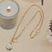 Gold-tone paperclip chain necklace with cubic zirconia sunburst pendant.