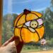 Halloween Mouse Suncatcher- in direct sunlight-  made of orange, light brown, light pink and brown glass.