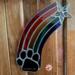 Rainbow Bridge Suncatcher- Black Paw - hanging on a wall.