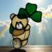 Saint Pat's Bear stained glass suncatcher in cream glass with dark green shamrock.