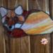 Fox Stained Glass Suncatcher by Robin C. Hary made in shades of red, orange, yellow, cream, and white glass. Hanging on a wall to show difference in glass with lighting.