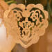 A handmade wooden Victorian-style fretwork floral heart Christmas tree ornament, featuring intricate cutout floral patterns in a heart shape, with a warm natural wood finish.