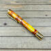 Red yellow and orange swirled resin rollerball pen with gold components 