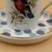 This is a closeup of the saucer and part of the bird on the teacup.  A variety of blues and each has gold trim. This is a closeup of the saucer and part of the bird on the teacup.  A variety of blues and each has gold trim.