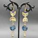Handmade celestial earrings with crescent and deep-blue glass beads, accented with steel spacer beads, 3 inches long.