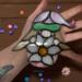 Girl Springtime Gnome stained glass suncatcher by Robin C. Hary being held for size reference.