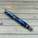 Chrome rollerball pen with purple, pink, and blue confetti ribbons