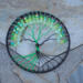 6 inch black yarn wrapped hoop cradles black and green wire tree of life, adorned with black and shades of green frosted glass beads. 