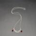 Handmade silver crescent moon phase necklace with red crystal teardrops on chain.