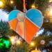 Heart-sun stained glass ornament- a heart shaped ornament with a sun in off centered at the top surrounded by blue glass as the sun rays come down to create the rest of the heart in shades of orange and yellow.