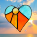 Heart-Sun stained glass ornament in shades of yellow/orange glass and blue.