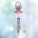 Angel stained glass wind chime- pink dress with blonde hair and white wings. Metal chimes hang down about 20" below the angel.