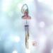 Angel stained glass wind chime- pink dress with blonde hair and white wings. Metal chimes hang down about 20" below the angel.