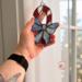 Candy Cane stained glass ornament being held for size reference- approximately 3" by 5"