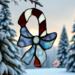Candy Cane stained glass ornament- made with red and white glass with a light blue bow.