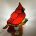 Cardinal Stained Glass Night Light- sitting on a brown glass branch with a green lampworked leaf, cardinal is made of bright red glass.