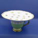 This gives an idea of the size, regular cup and saucer size. It's petite, 6.5 inches wide by 3.5 inches high. This gives an idea of the size, regular cup and saucer size. It's petite, 6.5 inches wide by 3.5 inches high.