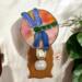 Dragonfly Stained Glass Night Light- in green and blue iridescent glass with yellow, orange mottle glass backdrop.