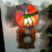 Dragonfly Stained Glass Night Light- in green and blue iridescent glass with yellow, orange mottle glass backdrop. Shown lite.