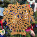 A handcrafted Victorian-style wooden Christmas tree ornament shaped like a basket filled with intricate floral designs, featuring detailed leaves and blossoms, with a small hook at the top for hanging.