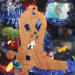Handmade wooden Christmas tree ornament shaped like a cowboy boot, featuring a sprig of holly On the side of the boot, and round berry accents.