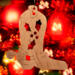 Handmade wooden Christmas tree ornament shaped like a cowboy boot, featuring a sprig of holly On the side of the boot, and round berry accents.
