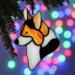 Corgi stained glass ornament shown hanging on a Christmas tree.