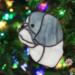 Shih Tzu stained glass ornament in Blue (gray) hanging on a Christmas tree.