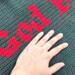 A close up of the word God in the God Bless Us Every One Tiny Tim quote. The maker's hand is in the photo for size context. A close up of the word God in the God Bless Us Every One Tiny Tim quote. The maker's hand is in the photo for size context.