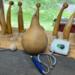 An unfinished gourd waiting to be carved. Several people shaped gourds stand in the back.