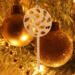 A handmade Christmas tree ornament crafted from light brown maple hardwood plywood, shaped like a lollipop with a round head featuring intricate spiral cutouts and a long stick handle, suspended from a small metal hook.