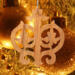 Intricate Victorian-style fretwork Christmas tree ornament handcrafted from natural hardwood with visible wood grain, showcasing symmetrical curls, loops, and ornate cut-out designs.