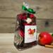 Apple Cinnamon Potpourri by Irish Twins. Bag with red and brown botanicals, a fresh apple, and cinnamon sticks.