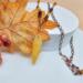 25 inch long handmade necklace with golden quartz leaf pendant, mahogany obsidian beads, and copper chain displayed with fall leaves